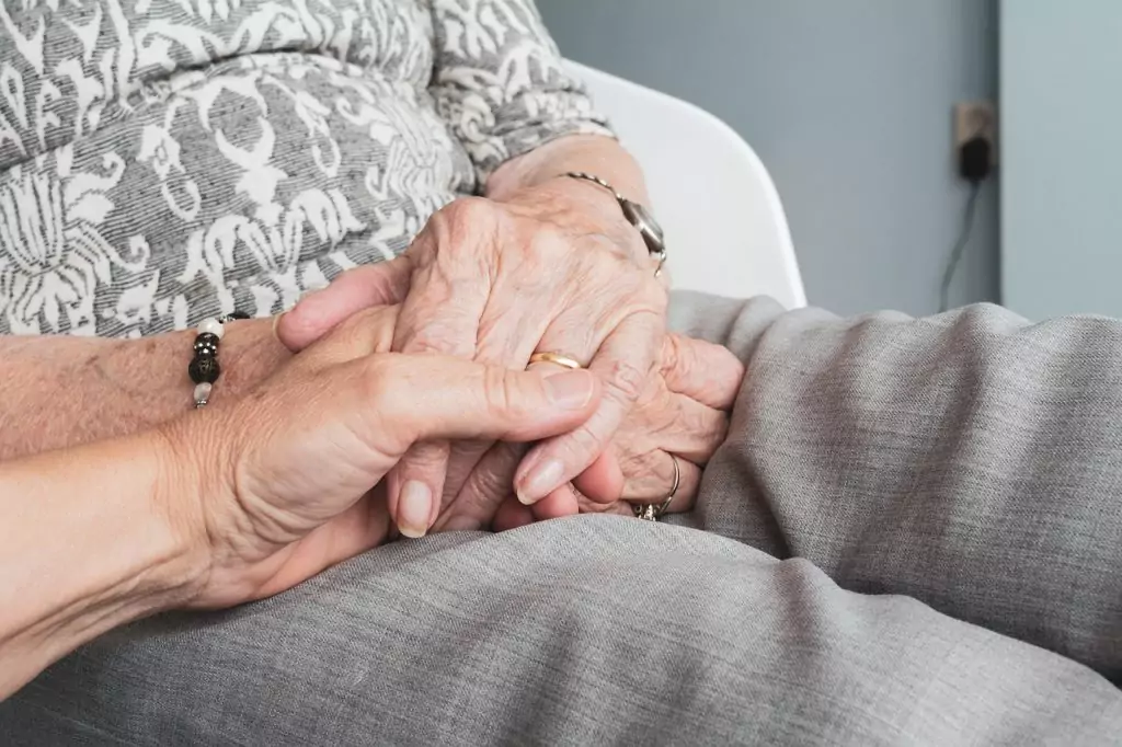 Faltige Hände einer Seniorin werden von einer helfenden Hand gehalten – Einblick in den Pflegealltag beim ambulanten Pflegedienst Helfende Hände in Hamburg